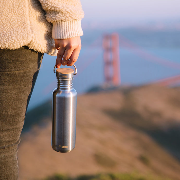 27oz-reflect-with-bamboo-cap-e1 K27SSLRF-BS-BAMBOO_reflect_bottle_bridge_lifestyle.jpg
